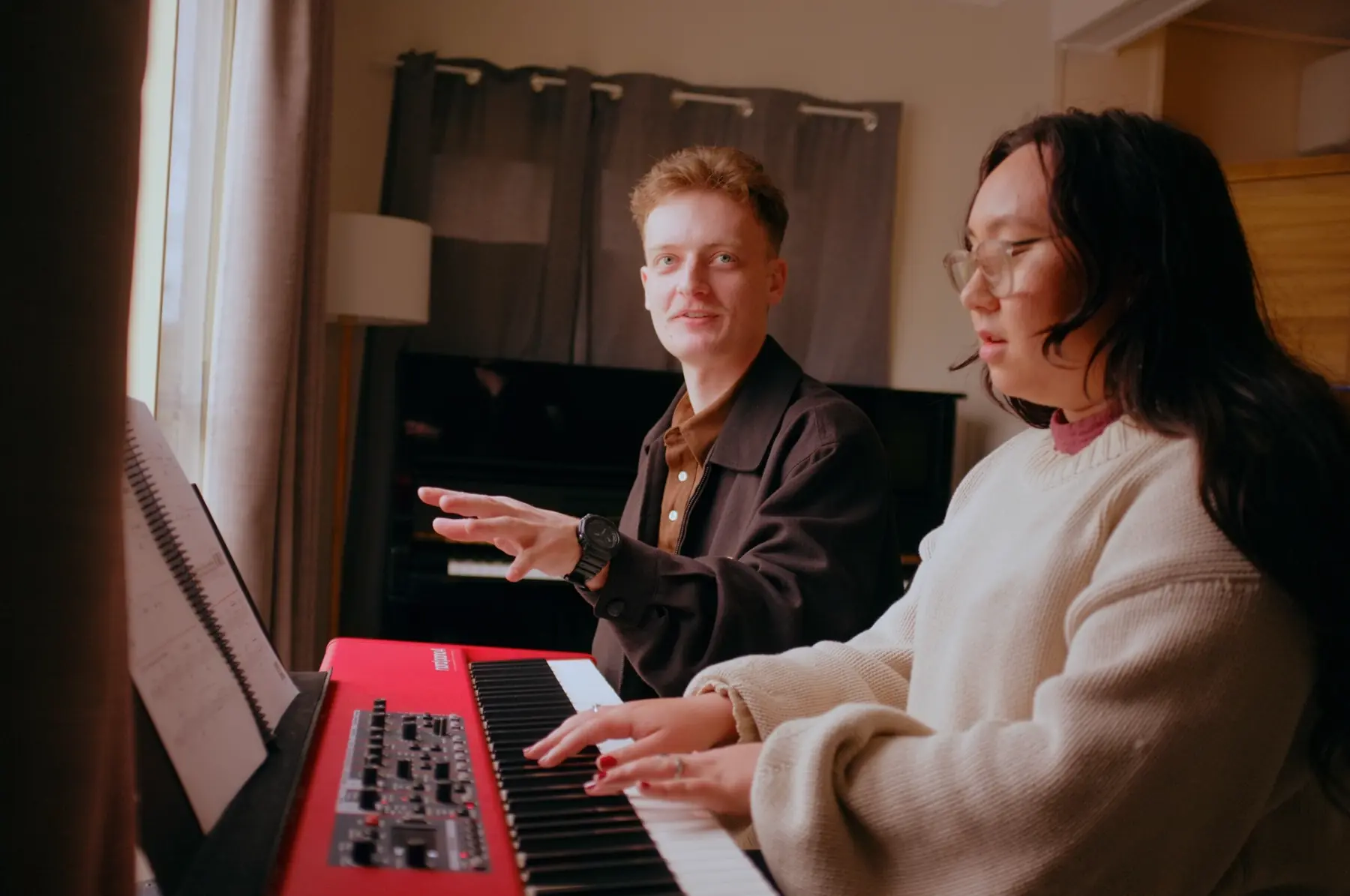 Reuben guiding an adult piano student during a private lesson